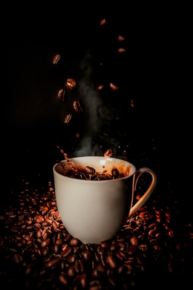 white ceramic teacup with coffee beans