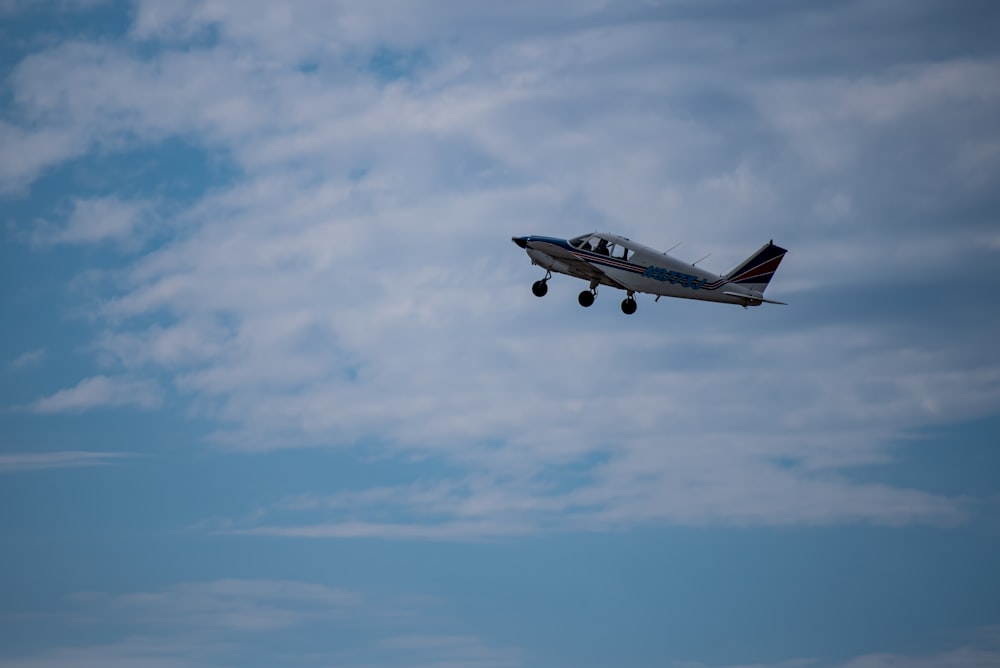 avion de passagers blanc dans les airs sous un ciel bleu pendant la journée