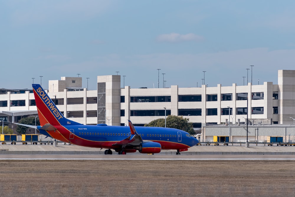 red and white passenger plane on airport during daytime