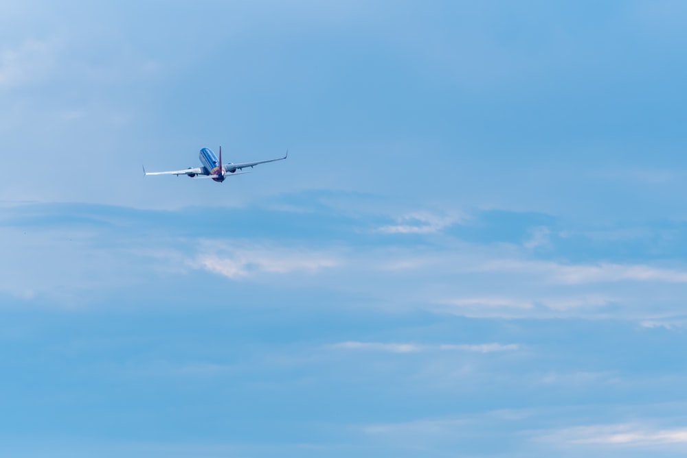 white and red airplane flying in the sky during daytime