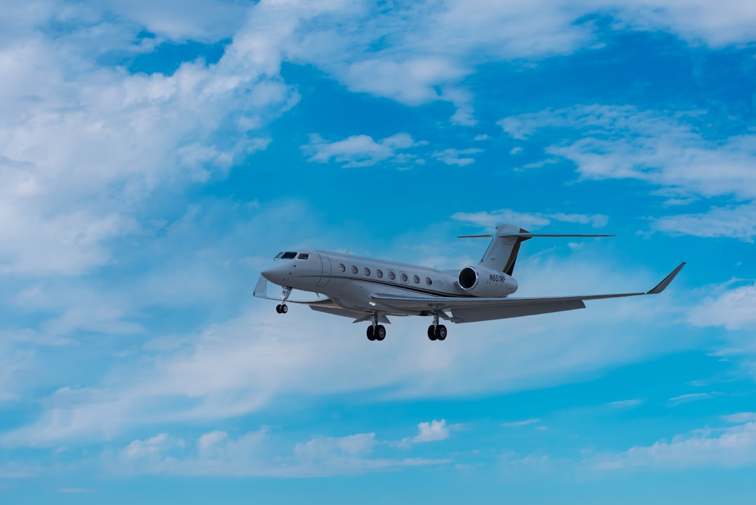 white passenger plane under blue sky and white clouds during daytime