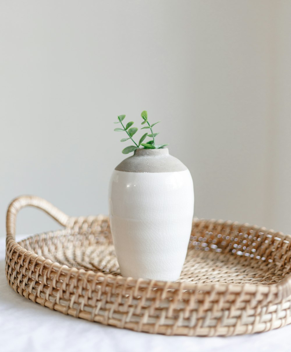 white ceramic vase on brown woven round table