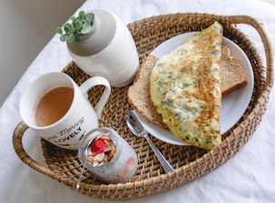 bread with egg on white ceramic plate beside white ceramic mug