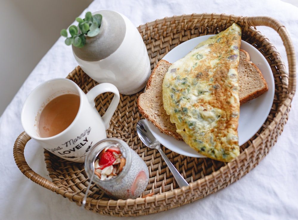 bread with egg on white ceramic plate beside white ceramic mug