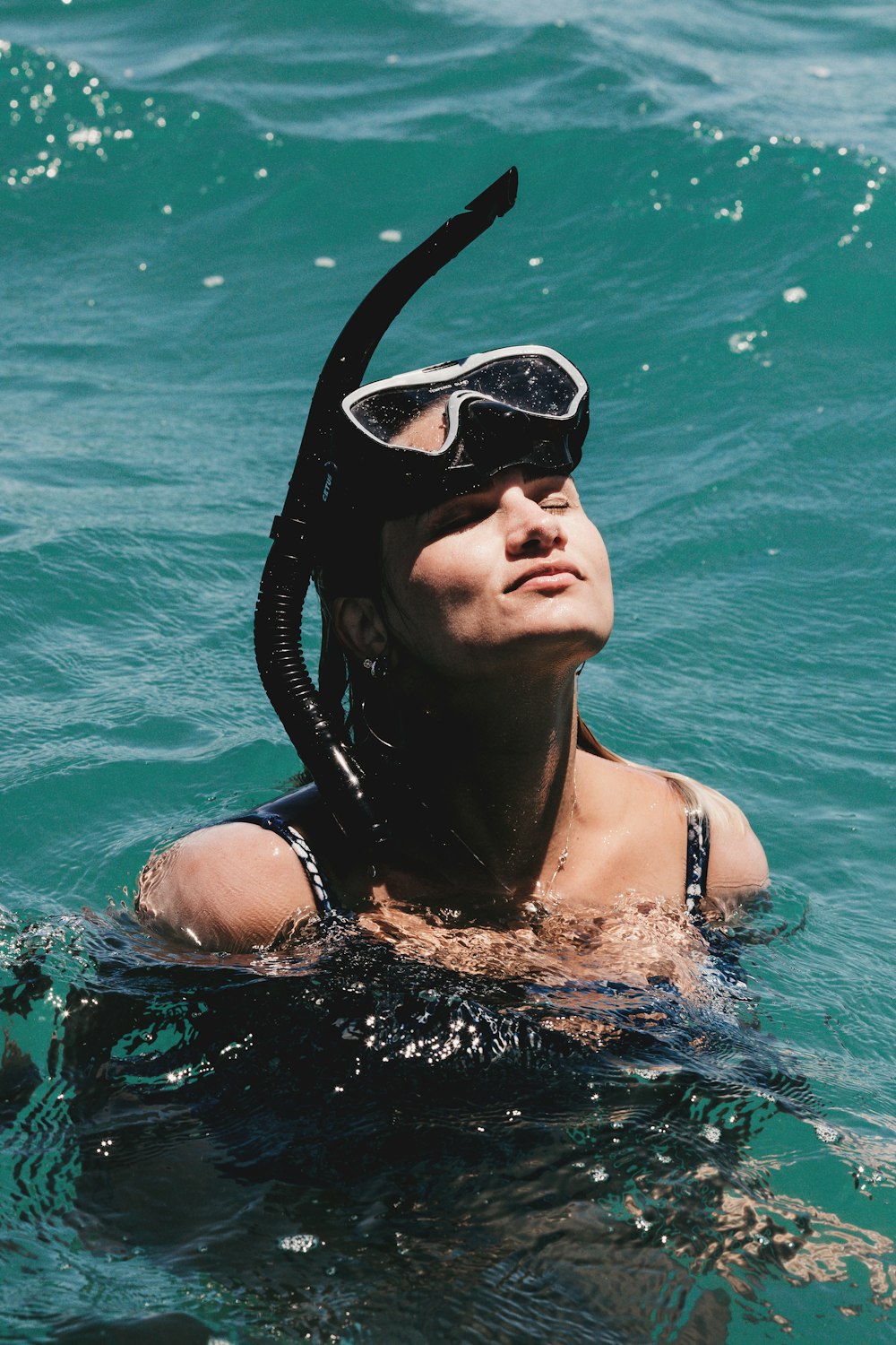 Frau in schwarzer Schwimmbrille im Wasser