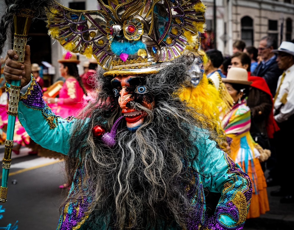 person in green blue and yellow feather costume