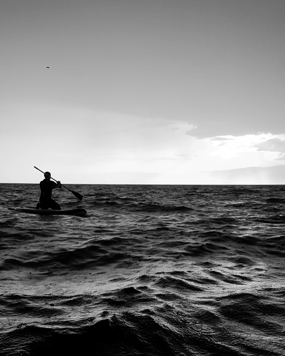 grayscale photo of man surfing on sea