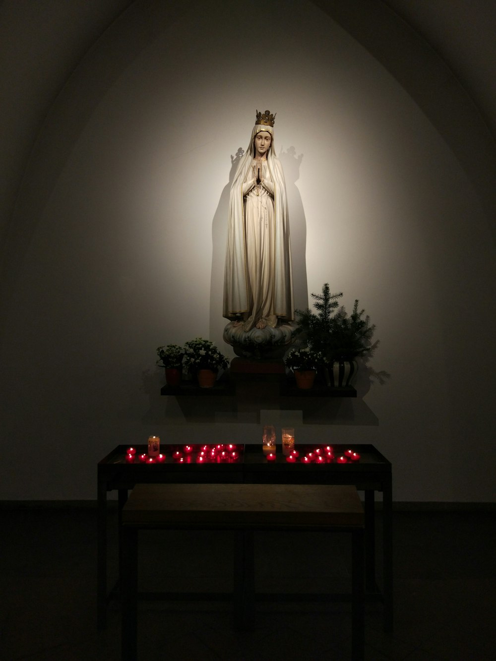 estatueta de jesus cristo na mesa de madeira marrom