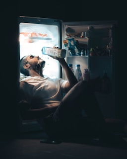 man in gray shirt drinking from glass