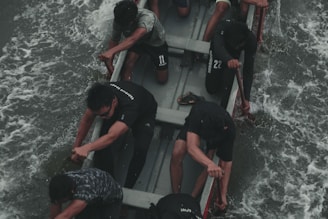 A group of men pushing through a tough outdoor workout, sweat and determination visible on their faces.