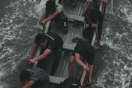 Close-up of a coach guiding athletes during an intense dragon boat training session.