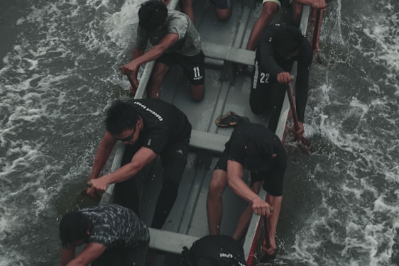 A group of men pushing through a tough outdoor workout, sweat and determination visible on their faces.