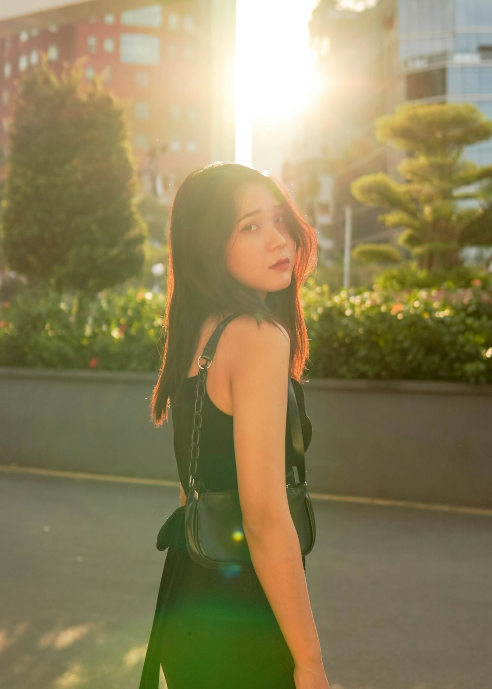 woman in green dress standing near green plants during daytime