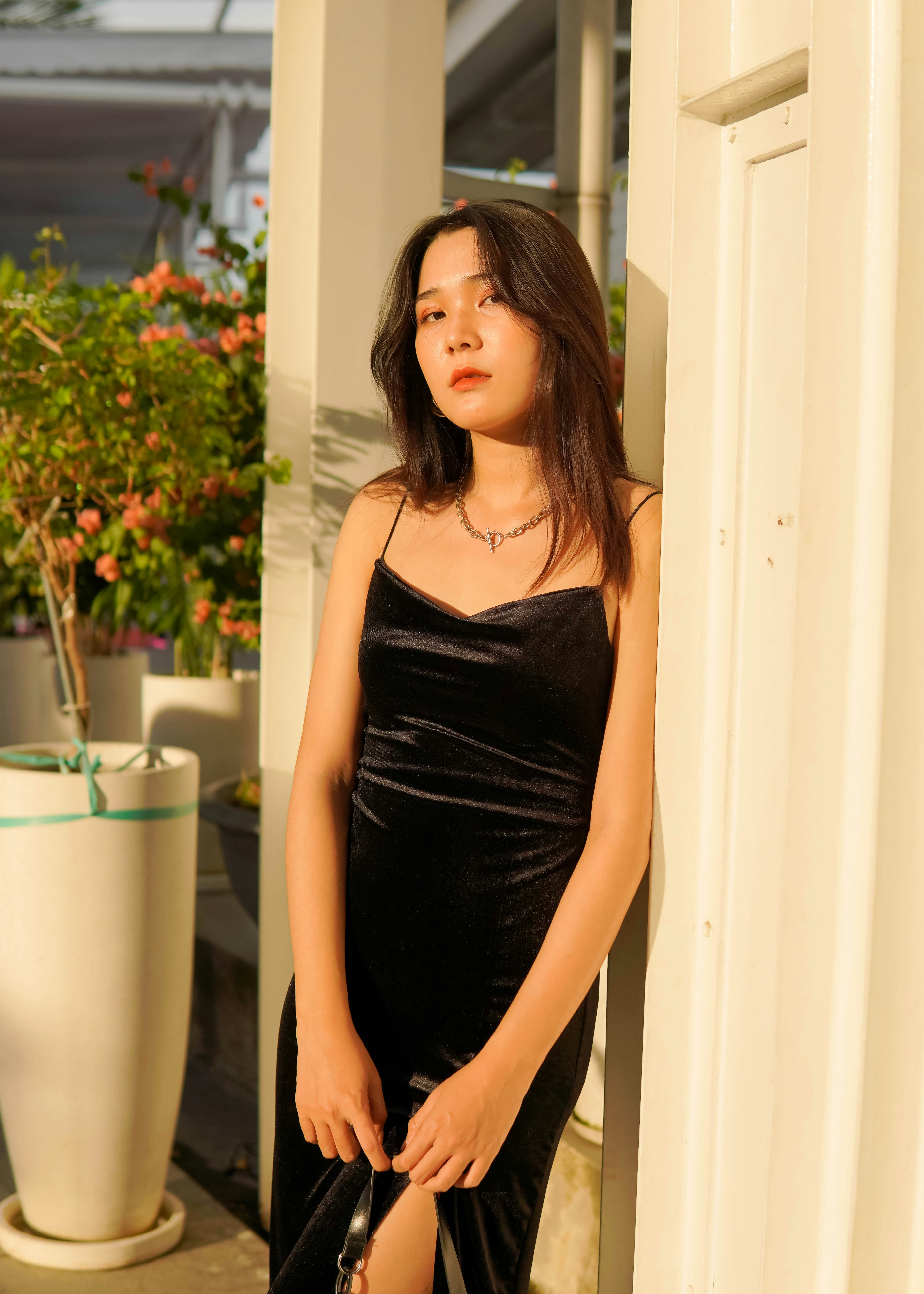 woman in purple spaghetti strap dress standing near white wooden door