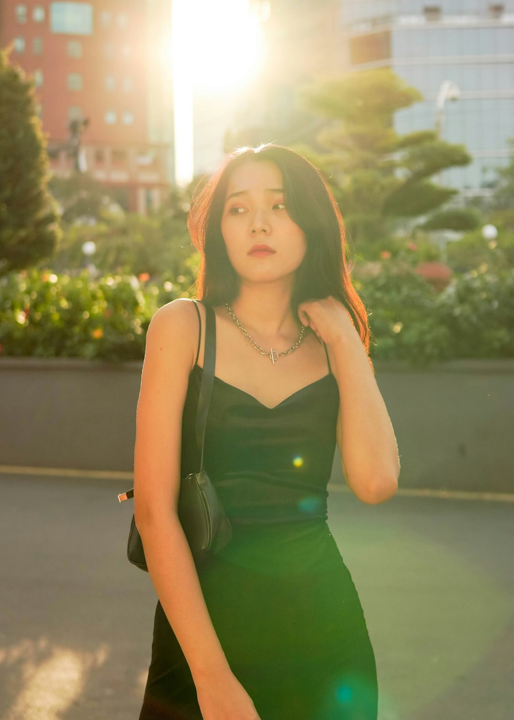 woman in green spaghetti strap dress standing on road during daytime