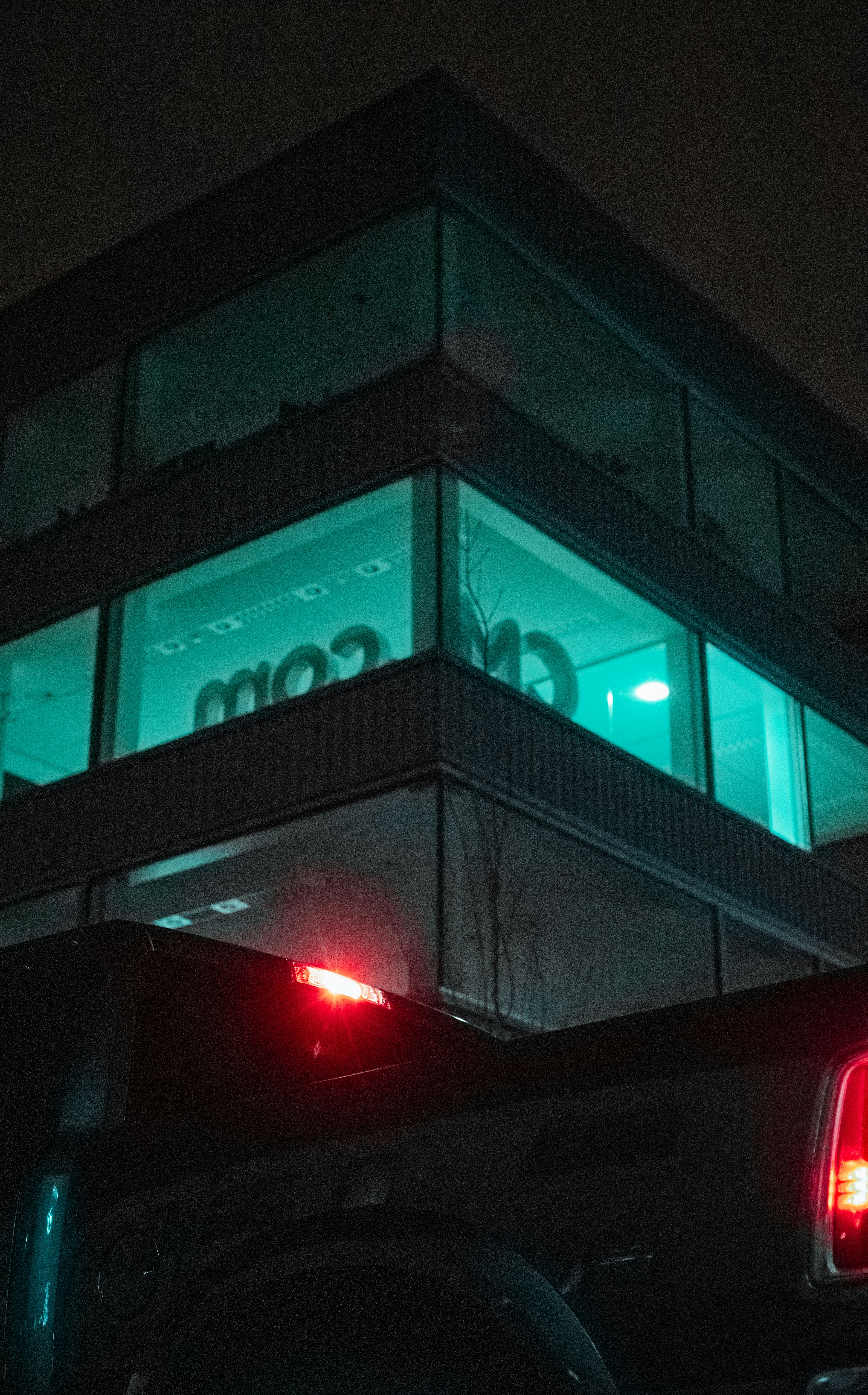 black car parked in front of building during night time