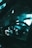 The image captures the interior of a vehicle, focusing on the steering wheel and illuminated dashboard. The dashboard displays light up with various gauges and indicators, set within a dimly lit car interior. The lighting has a cool teal tone, creating an atmospheric and futuristic look.