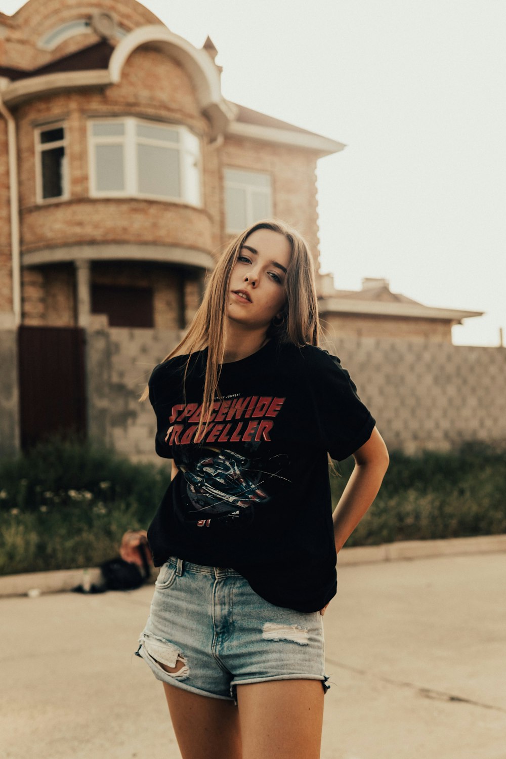 Woman in black crew neck t-shirt and blue denim shorts standing on street  during daytime photo – Free Apparel Image on Unsplash