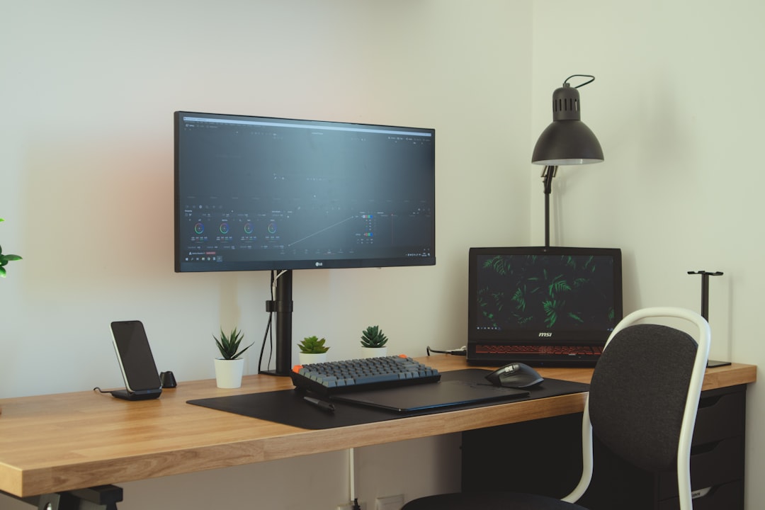 black flat screen computer monitor on brown wooden desk,