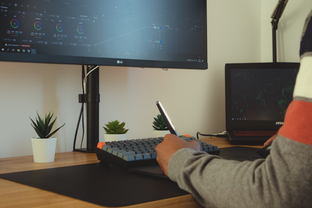 black flat screen computer monitor and black computer keyboard on brown wooden desk