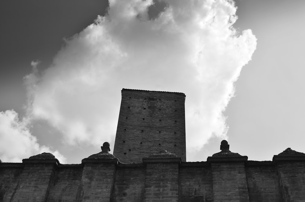 Graues Betongebäude unter weißen Wolken tagsüber