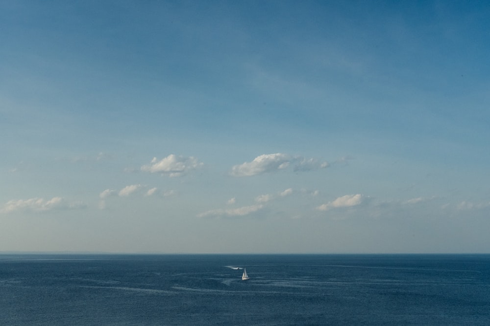 white boat on sea under blue sky during daytime