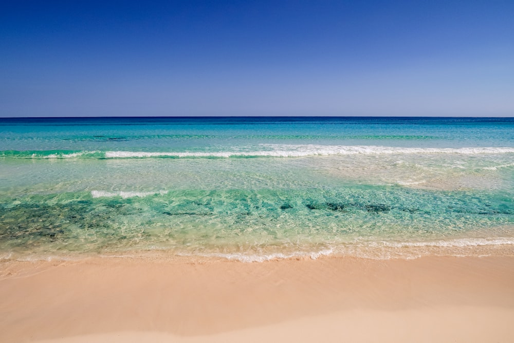 ocean waves crashing on shore during daytime