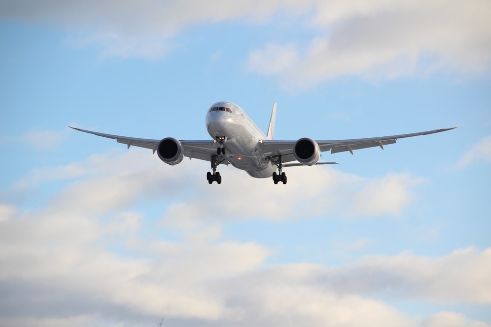 avião de passageiros branco no ar durante o dia