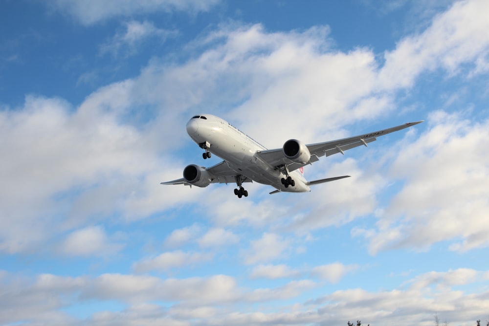 Weißes Flugzeug tagsüber unter blauem Himmel