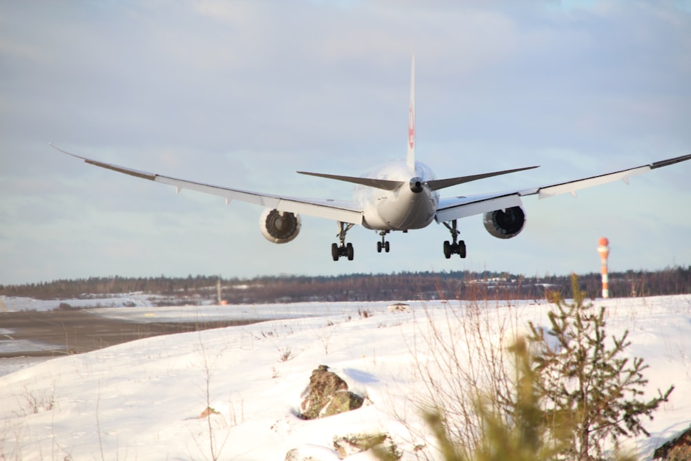 avion blanc sur un champ de neige blanche pendant la journée