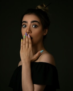 woman in black off shoulder shirt with blue manicure
