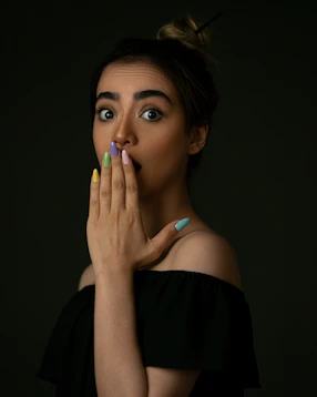 woman in black off shoulder shirt with blue manicure