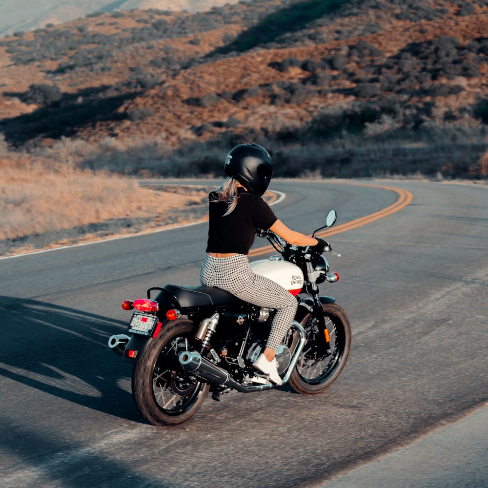 man in black shirt riding motorcycle on road during daytime