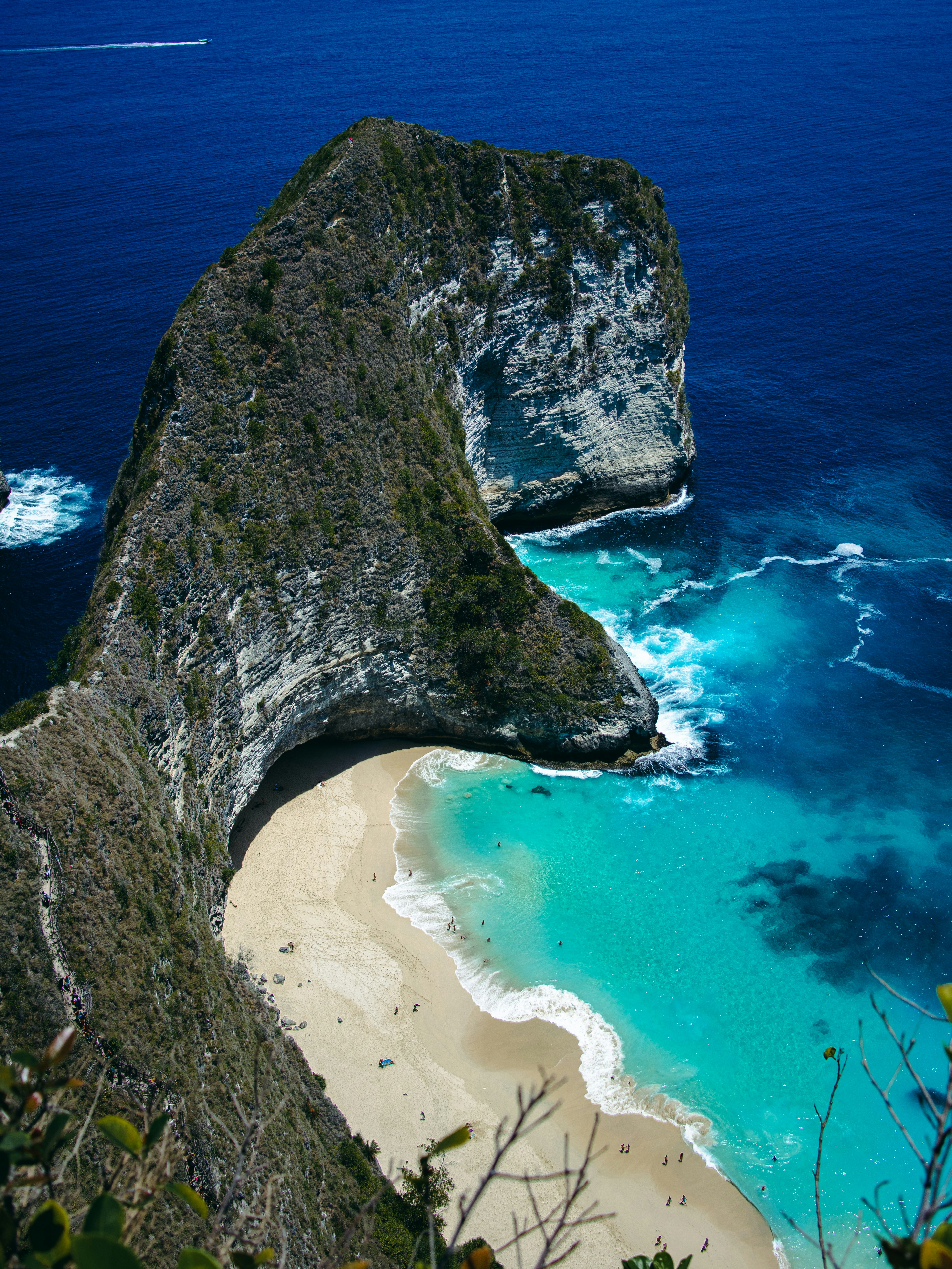 aerial view of green and brown rock formation on beach during daytime