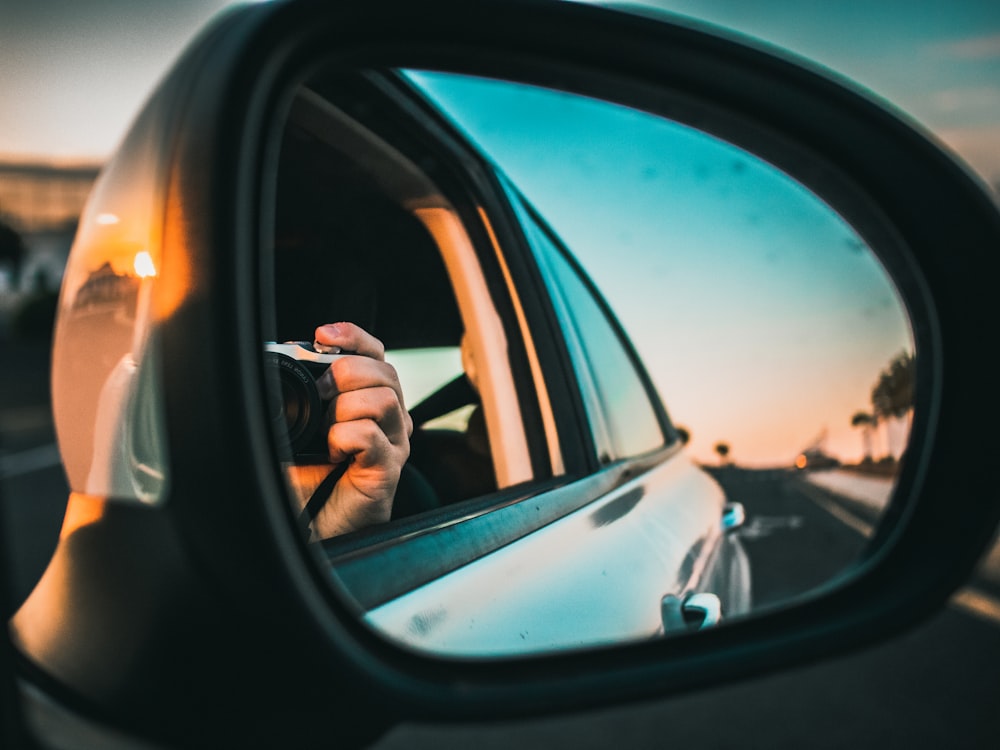 person in black sunglasses driving car during daytime