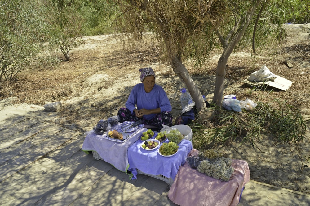 man in blue jacket sitting on ground