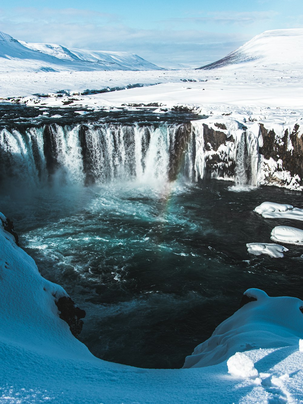 water falls on rocky shore during daytime