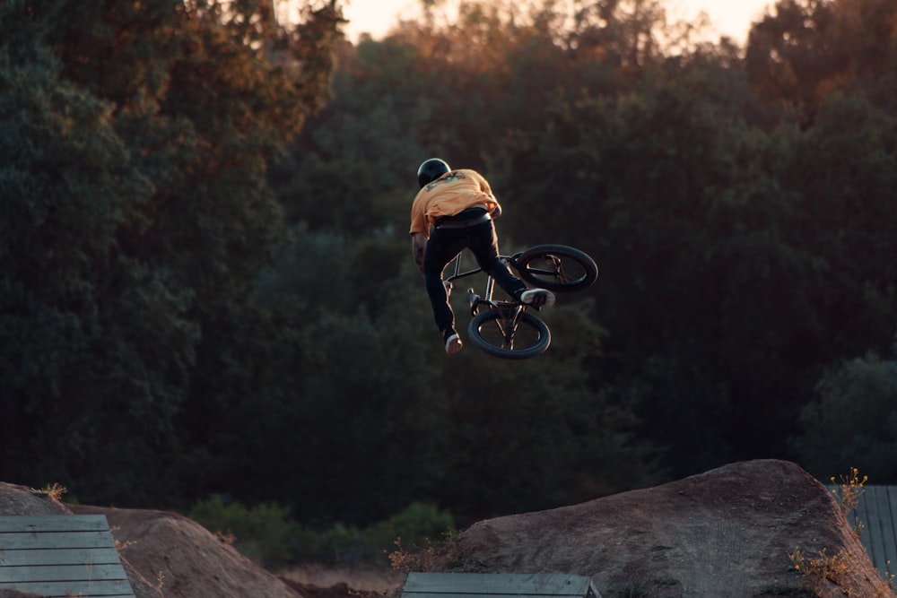 man in brown shirt riding bicycle on brown rock during daytime