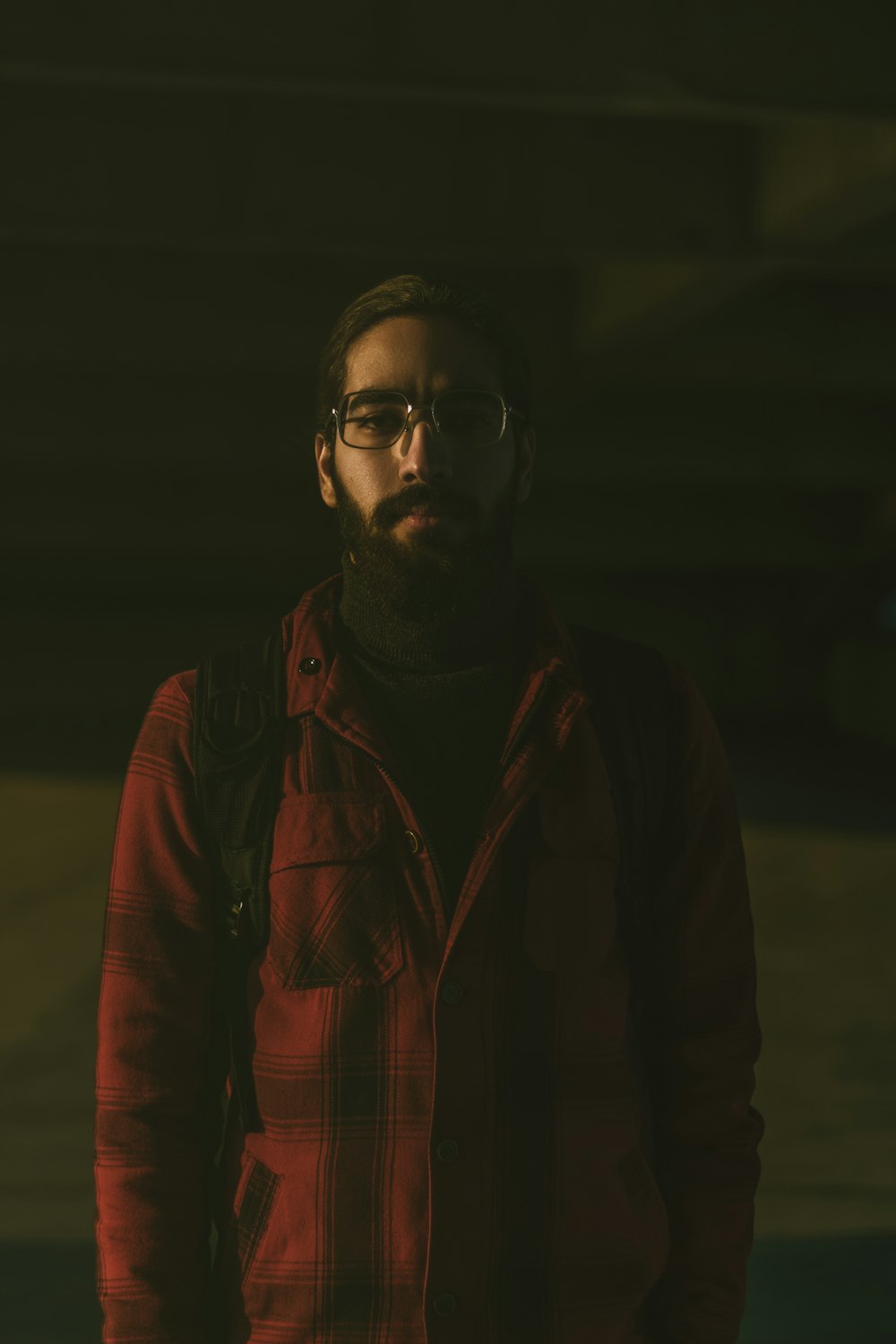 man in red jacket wearing eyeglasses