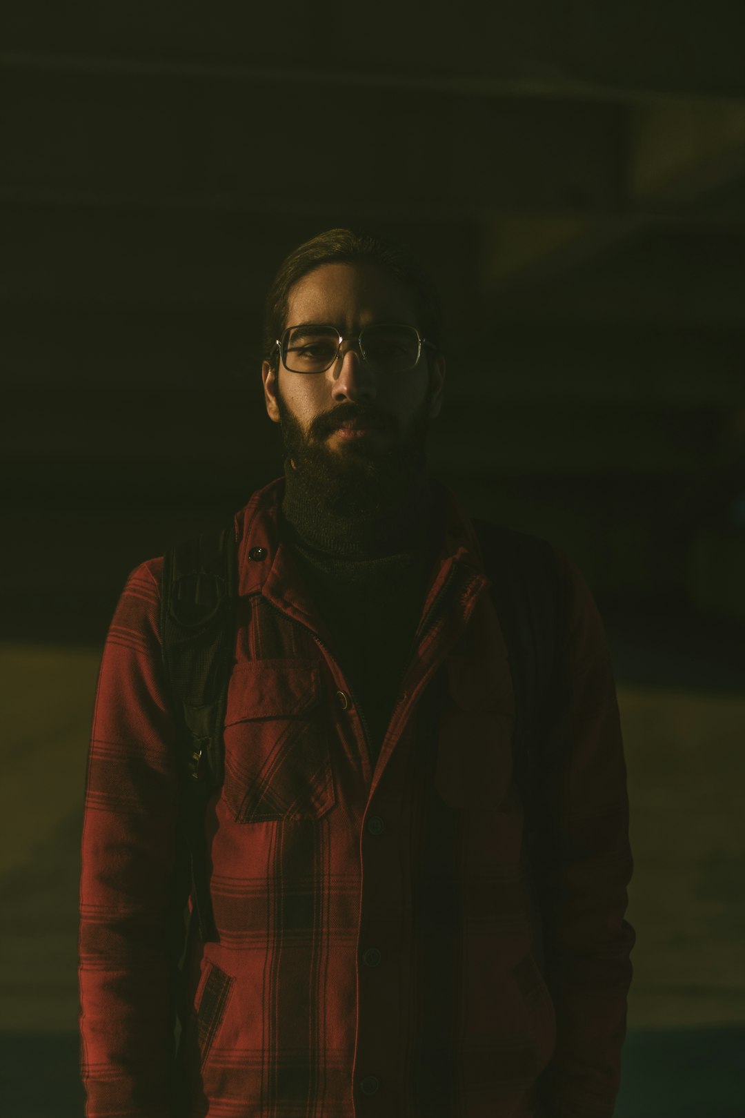 man in red jacket wearing eyeglasses