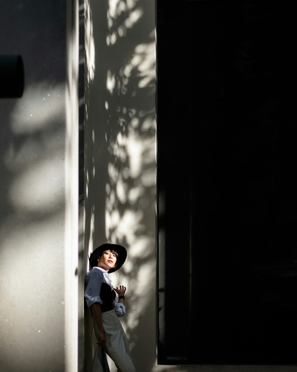 boy in blue shirt and white cap standing beside window