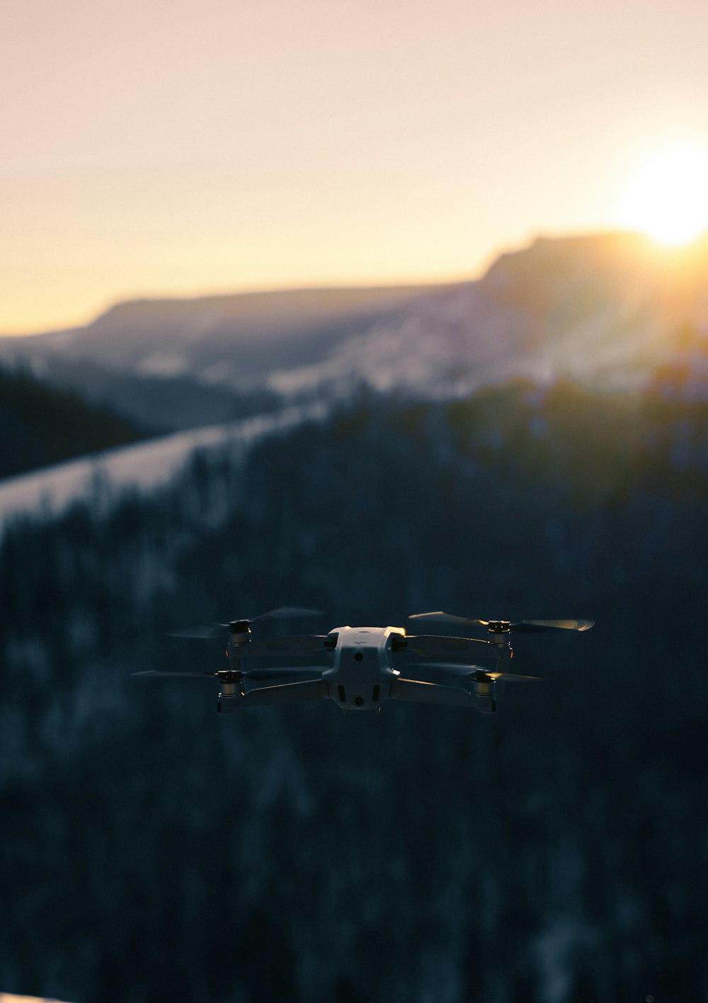 drone branco e preto voando sobre as árvores verdes durante o dia