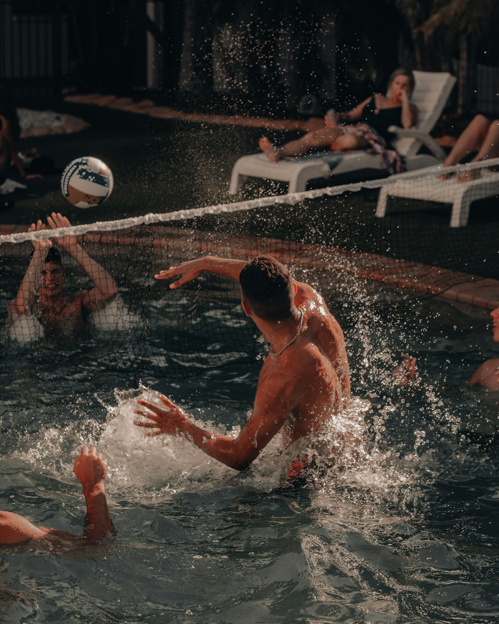 man in swimming pool playing volleyball