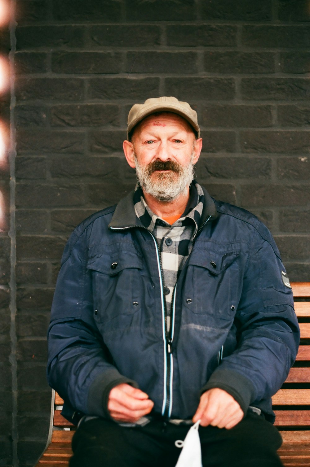 man in blue zip up jacket and brown hat