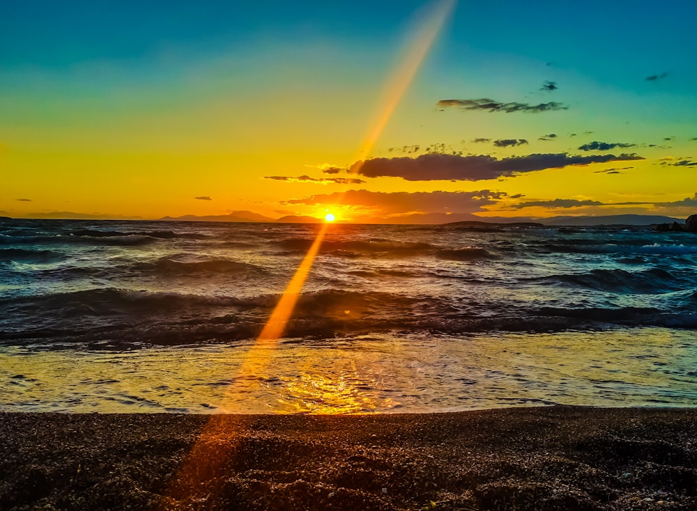 Olas del mar rompiendo en la costa durante la puesta de sol