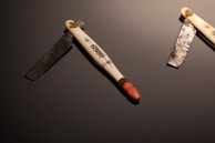 An elegant display of various handcrafted razors on a wooden table.