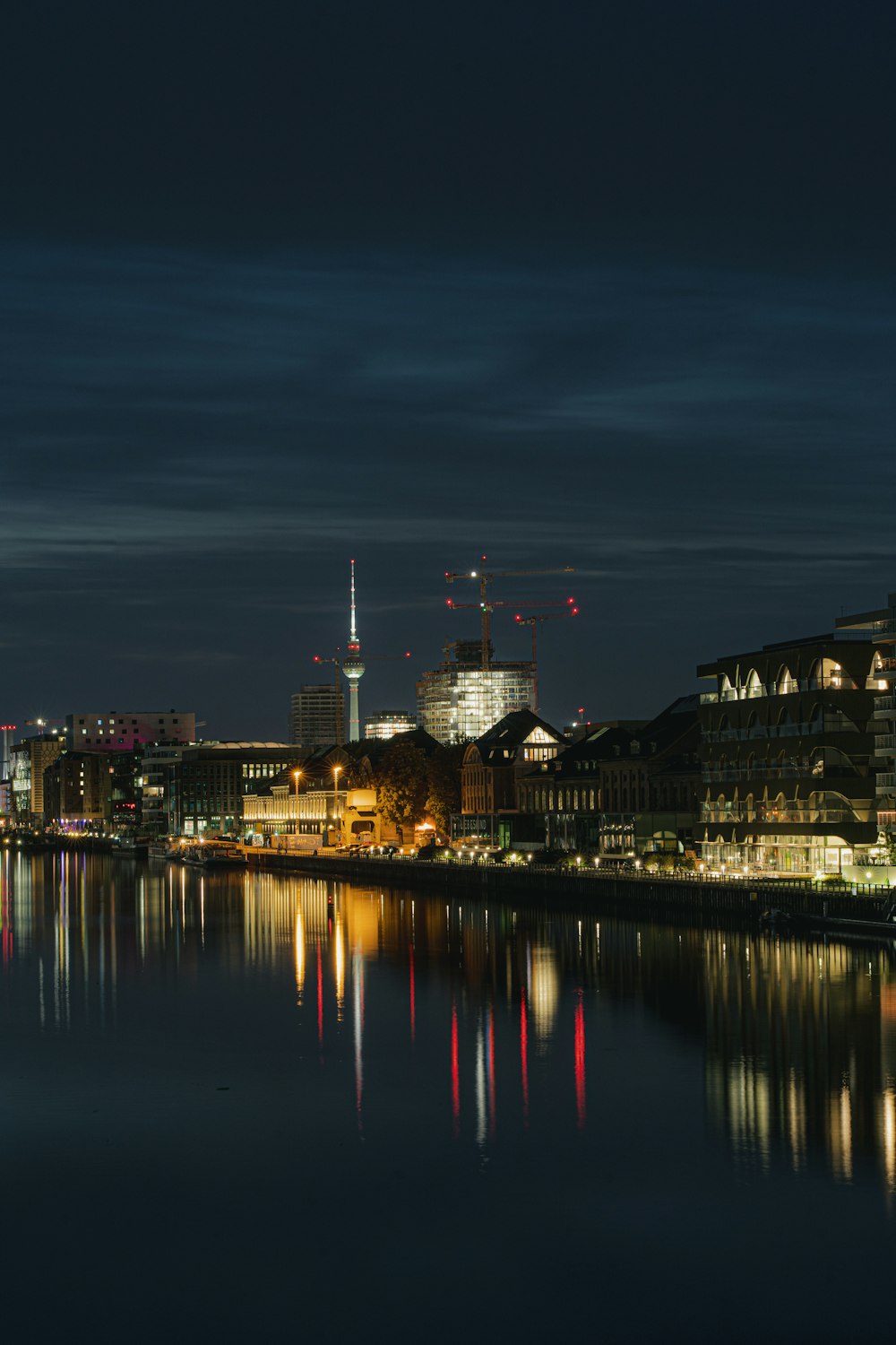 body of water near city buildings during night time