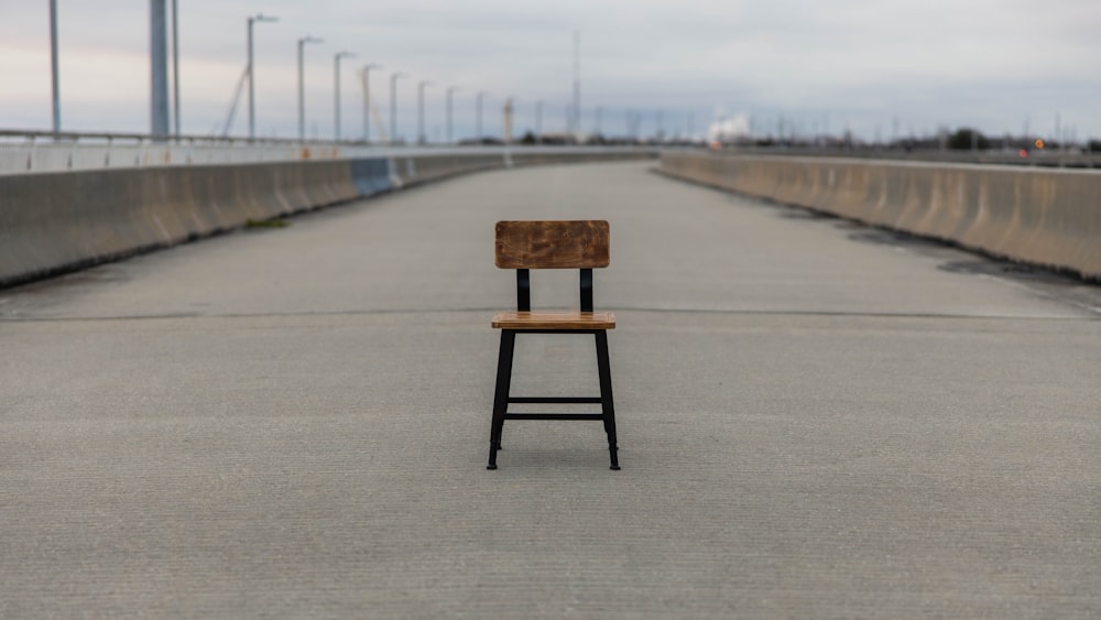 brown wooden seat on gray concrete road during daytime
