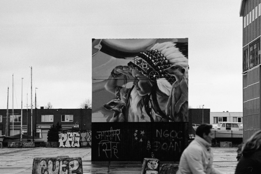 grayscale photo of man and woman standing near statue