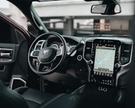 Dashboard close-up with tactile controls and a large touchscreen displaying vehicle stats.